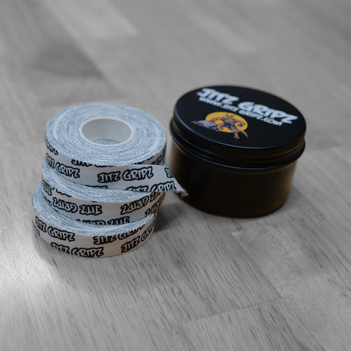 JitzGripz finger tape rolls beside branded storage tin for BJJ athletes
