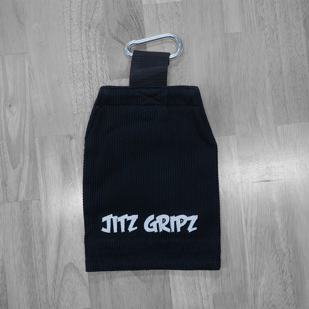 JitzGripz Gi sleeve grip trainer lying on floor with metal carabiner