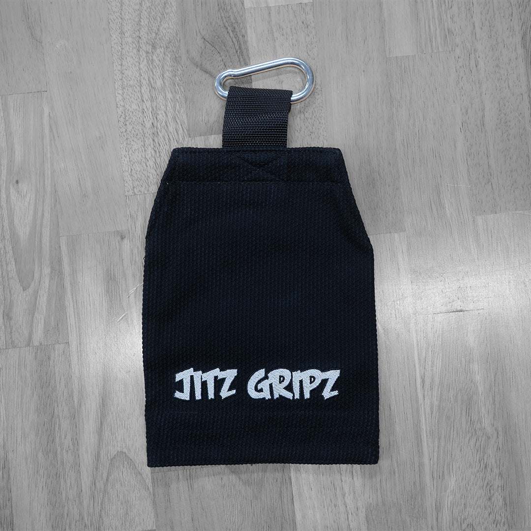 JitzGripz Gi sleeve grip trainer lying on floor with metal carabiner